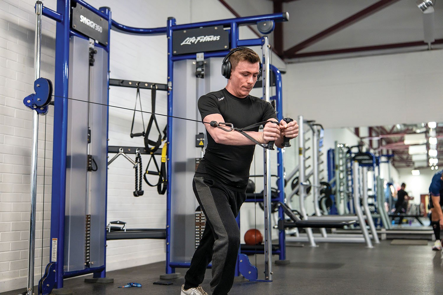 Man in a gym doing a cable chest fly on the machine